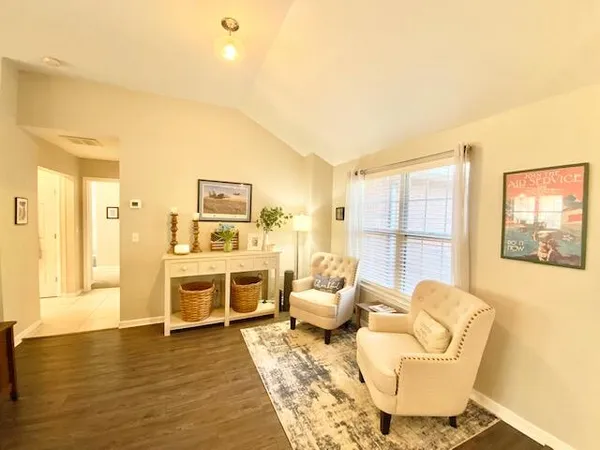 a living room with furniture a large window and kitchen view