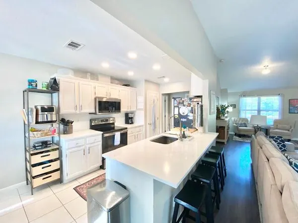 a kitchen with a sink a stove and chairs