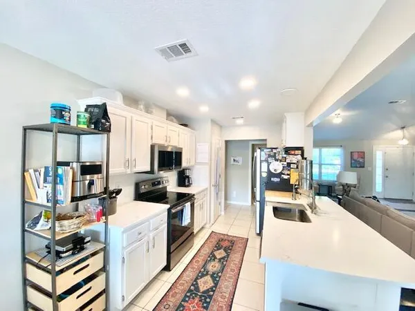 a large kitchen with a large counter top appliances and cabinets