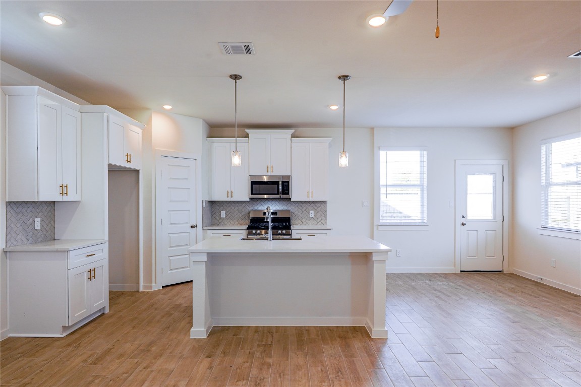 6618 Escondido Drive Rosharon, TX 77583 - Photo 12 of 31 a kitchen with cabinets and wooden floor