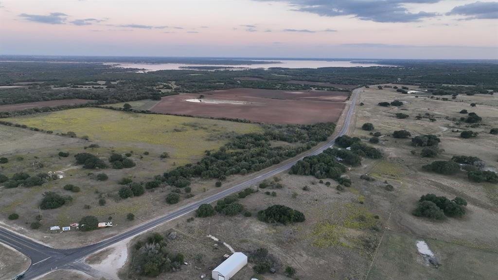 Aerial view at dusk featuring a water view and a rural view