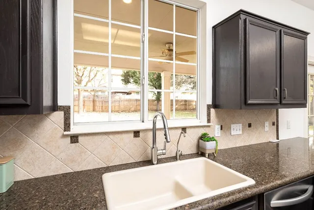 a kitchen with granite countertop a sink and a window