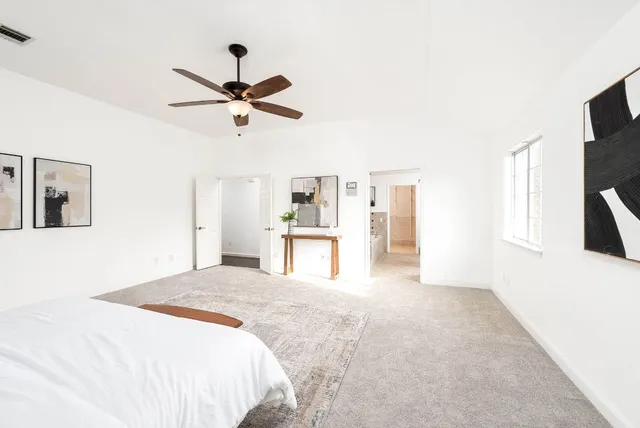 a bed sitting in a bedroom next to a window with potted plant