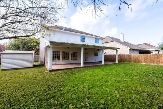a front view of a house with a garden and trees