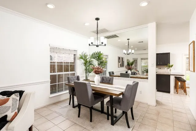 a dining room with furniture a chandelier and window