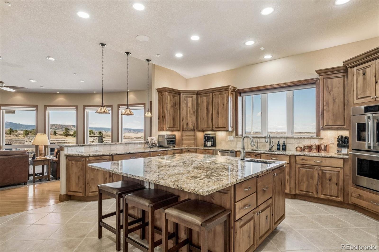 3959 Serenade Road Castle Rock, CO 80104 - Photo 16 of 50 a kitchen with center island table and chairs