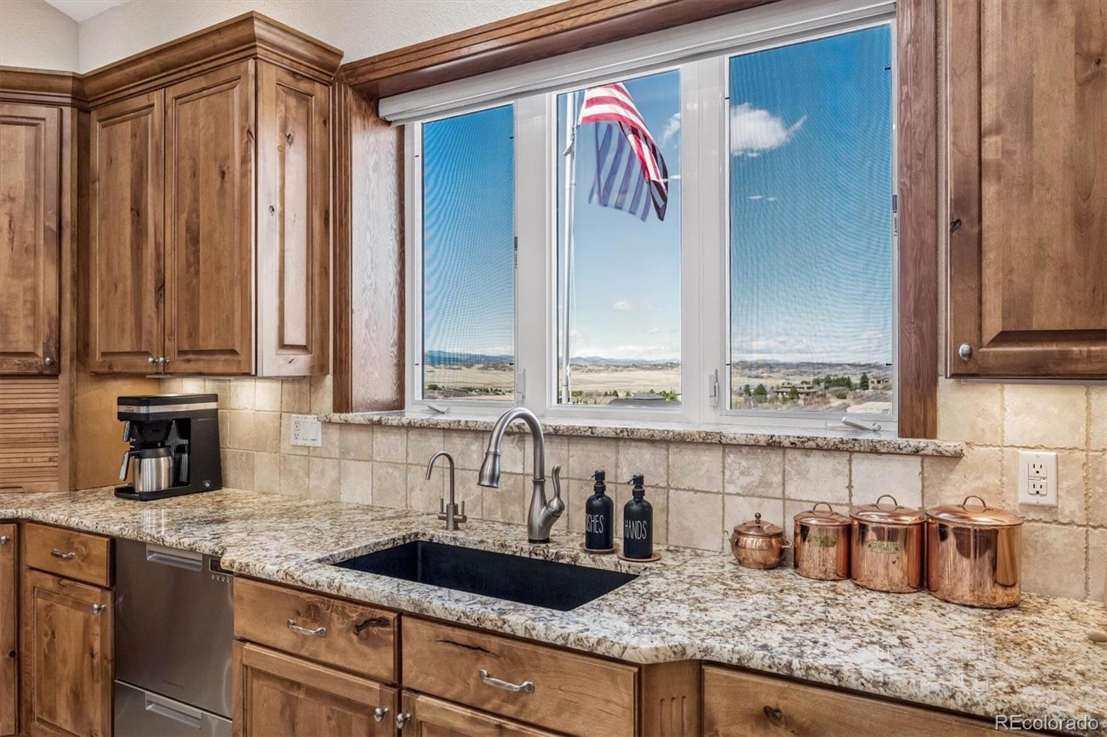 3959 Serenade Road Castle Rock, CO 80104 - Photo 17 of 50 a kitchen with granite countertop a sink and cabinets