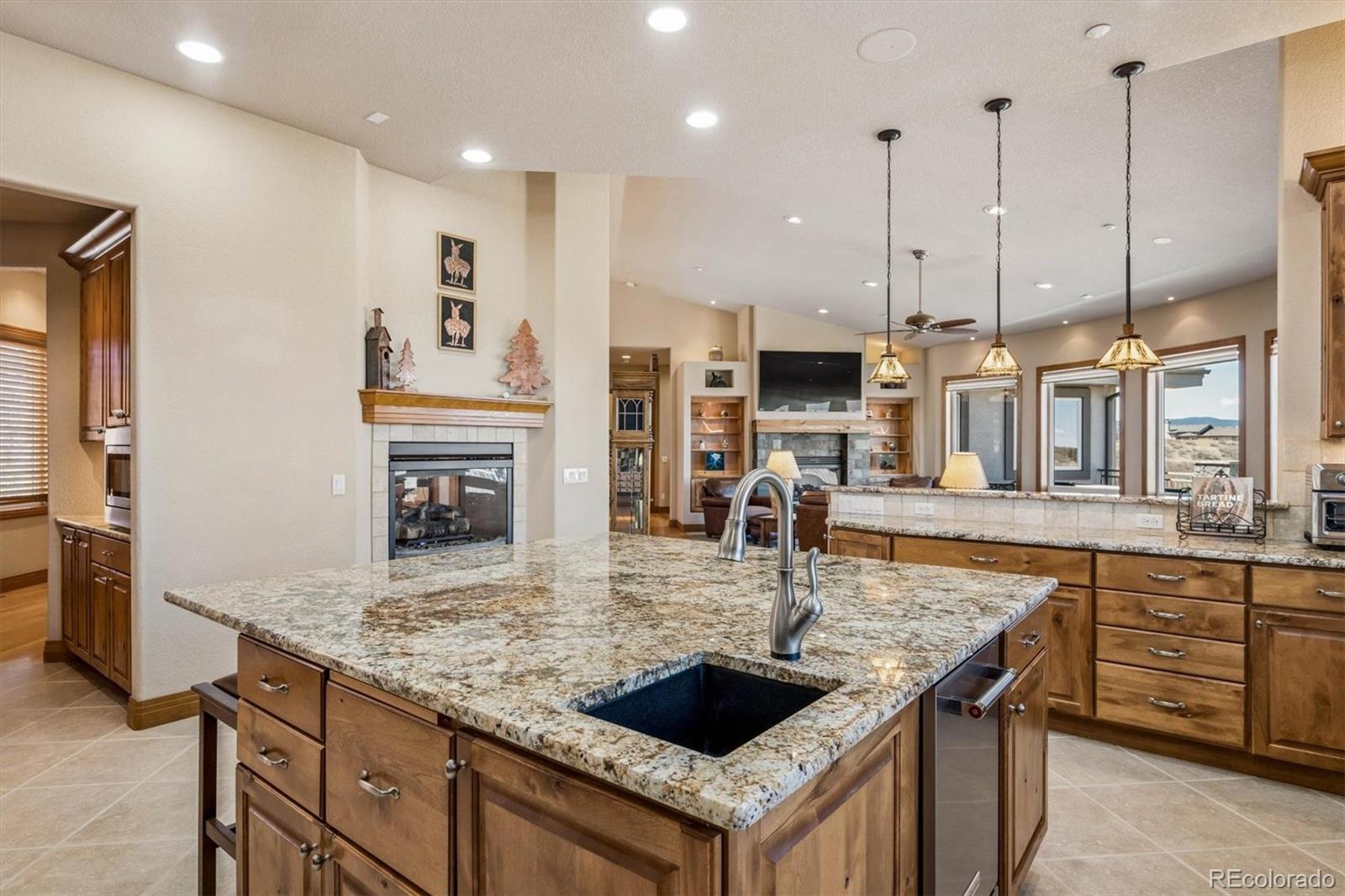 3959 Serenade Road Castle Rock, CO 80104 - Photo 18 of 50 a kitchen with kitchen island granite countertop a stove and a sink