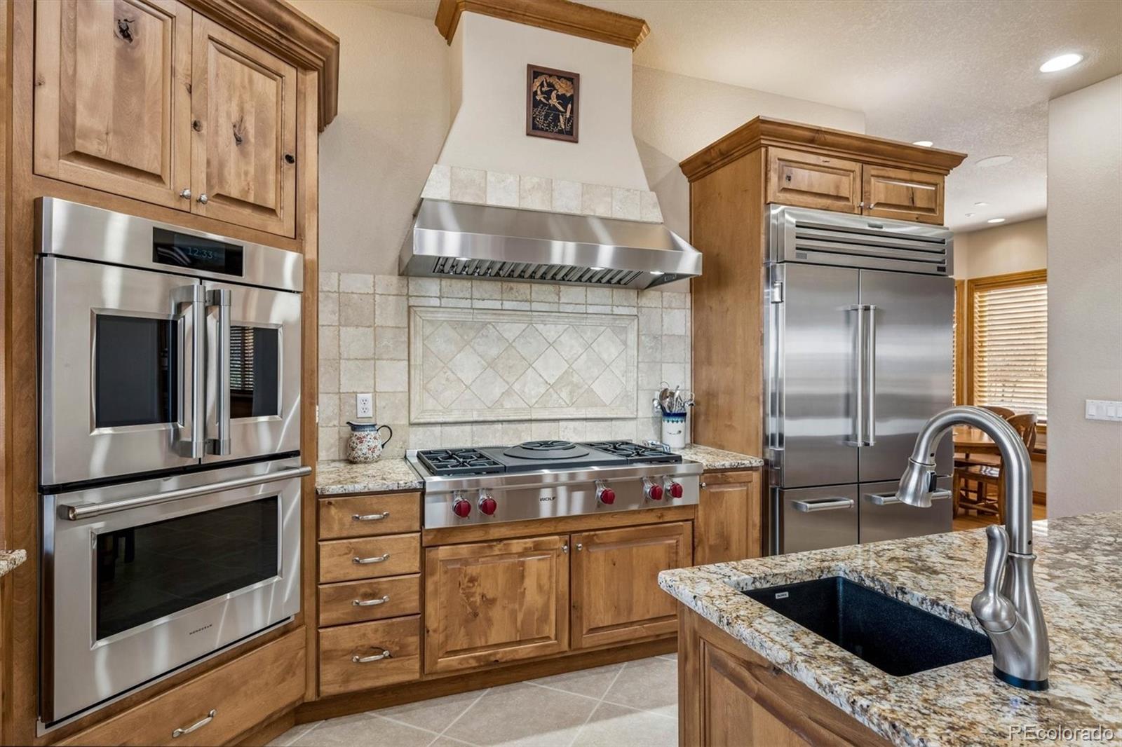 3959 Serenade Road Castle Rock, CO 80104 - Photo 19 of 50 a kitchen with granite countertop a stove and a sink