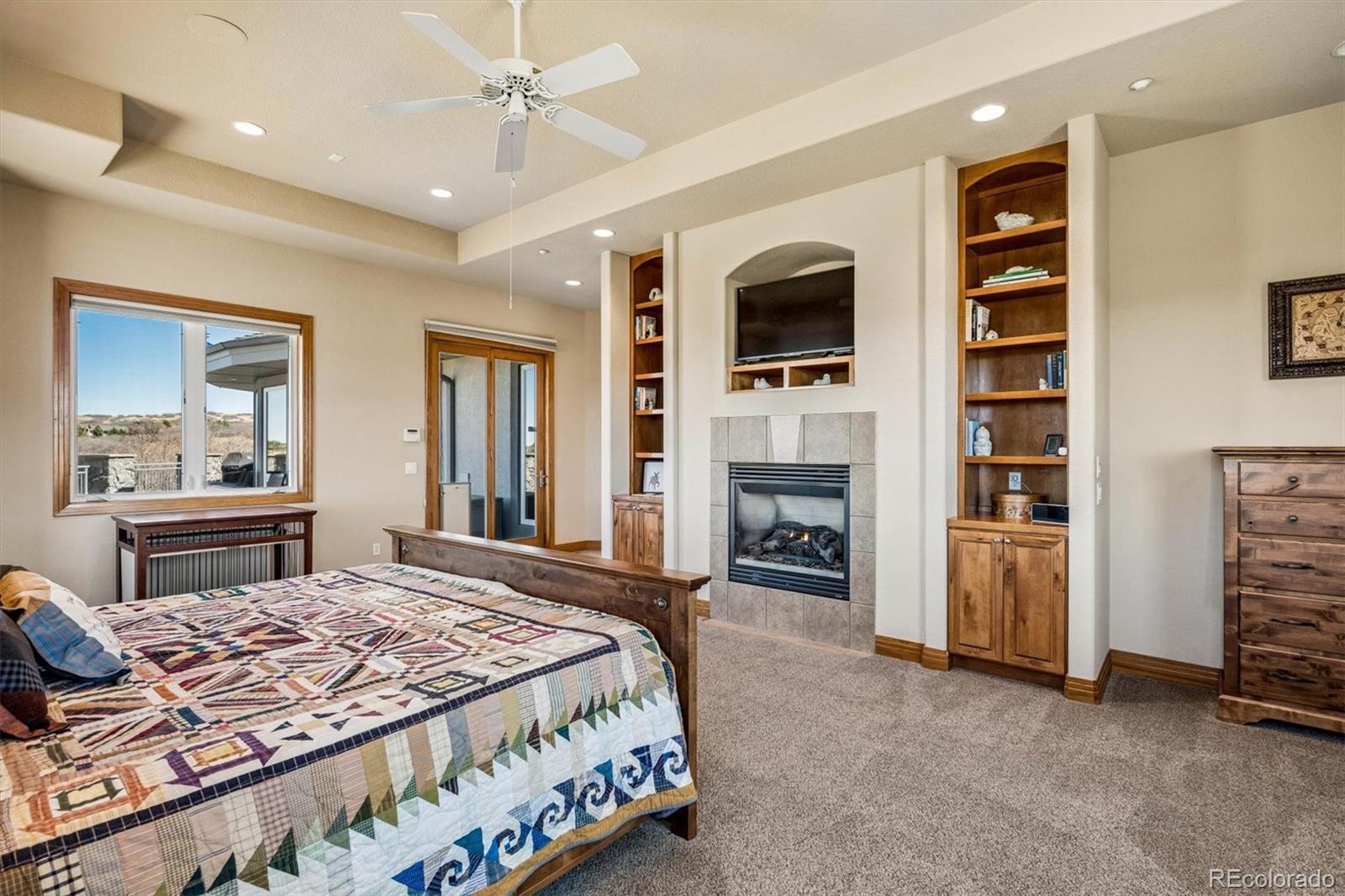 3959 Serenade Road Castle Rock, CO 80104 - Photo 26 of 50 a bedroom with a bed dresser and a flat screen tv