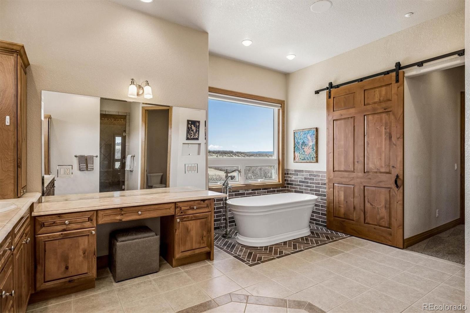 3959 Serenade Road Castle Rock, CO 80104 - Photo 29 of 50 a spacious bathroom with a sink a mirror and a bathtub