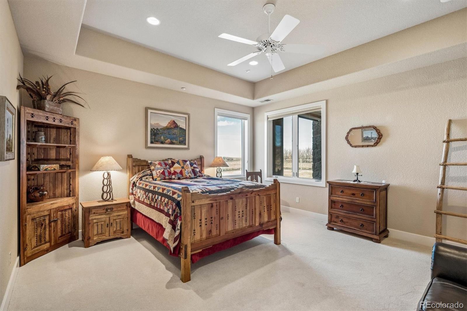 3959 Serenade Road Castle Rock, CO 80104 - Photo 30 of 50 a spacious bedroom with a bed a couch and large window