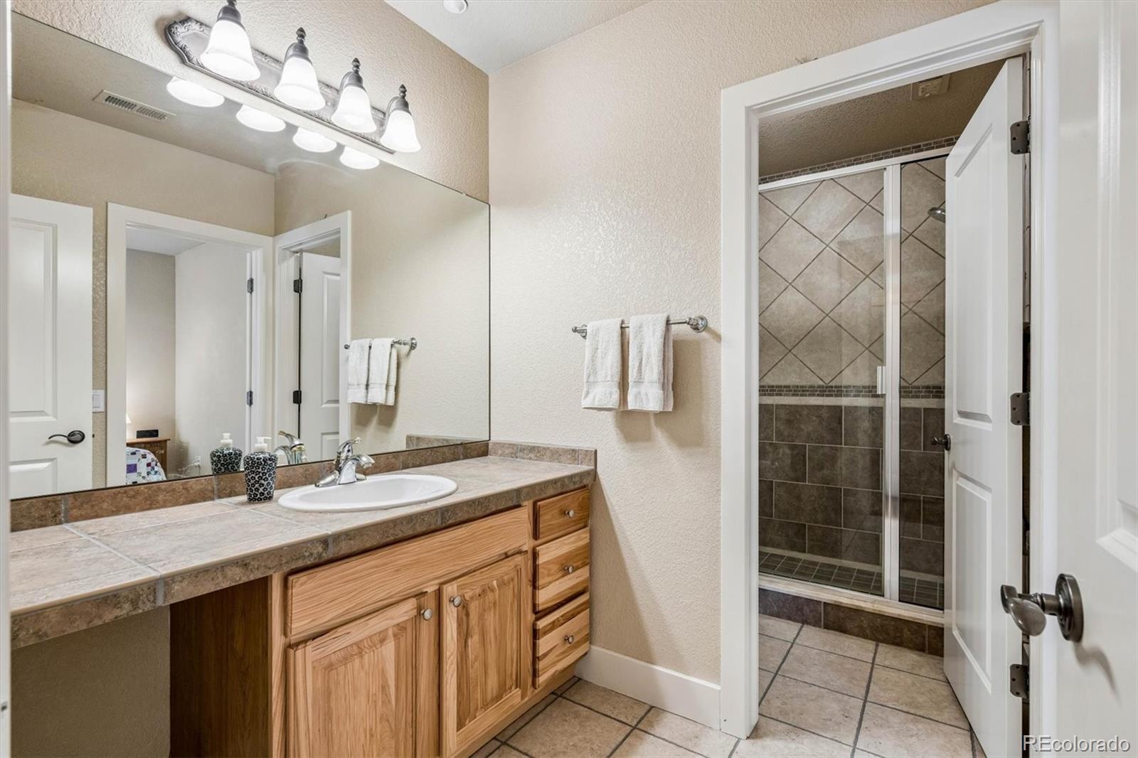 3959 Serenade Road Castle Rock, CO 80104 - Photo 36 of 50 a bathroom with a double vanity sink and a mirror