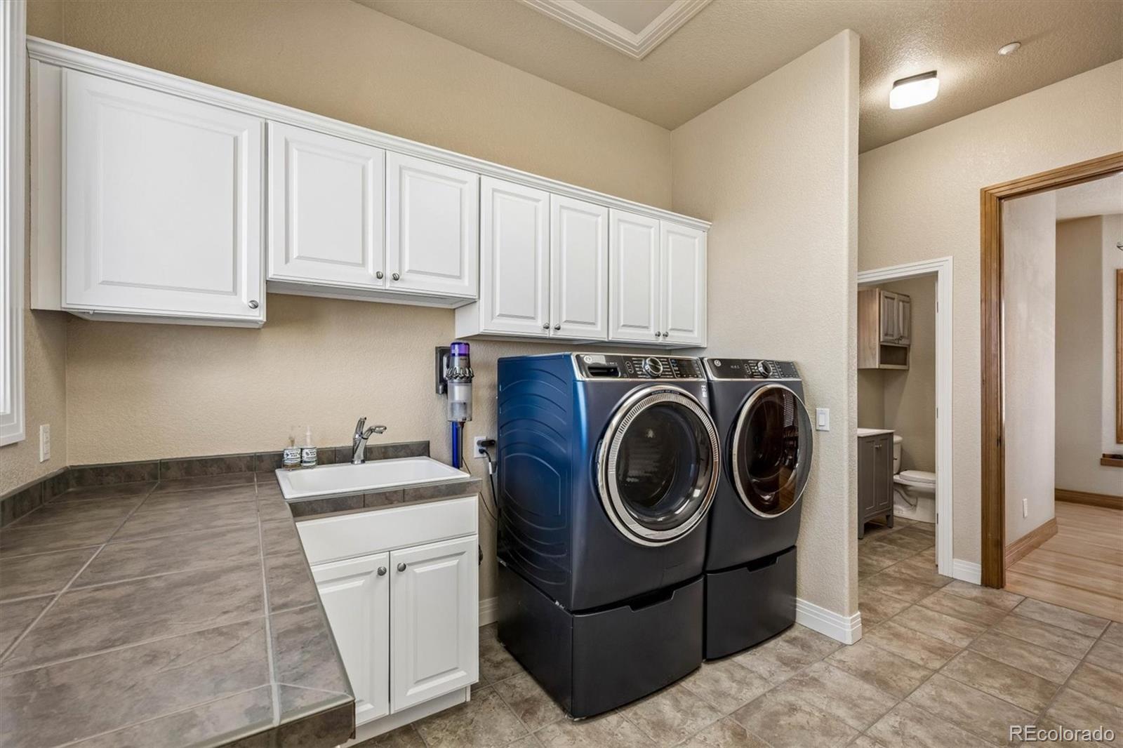 3959 Serenade Road Castle Rock, CO 80104 - Photo 43 of 50 a utility room with sink dryer and washer