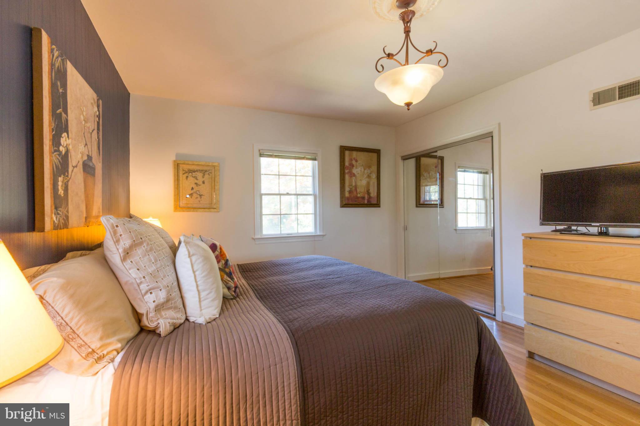207 Indian Spring Drive Silver Spring, MD 20901 - Photo 19 of 30 a bedroom with a large bed and a flat screen tv