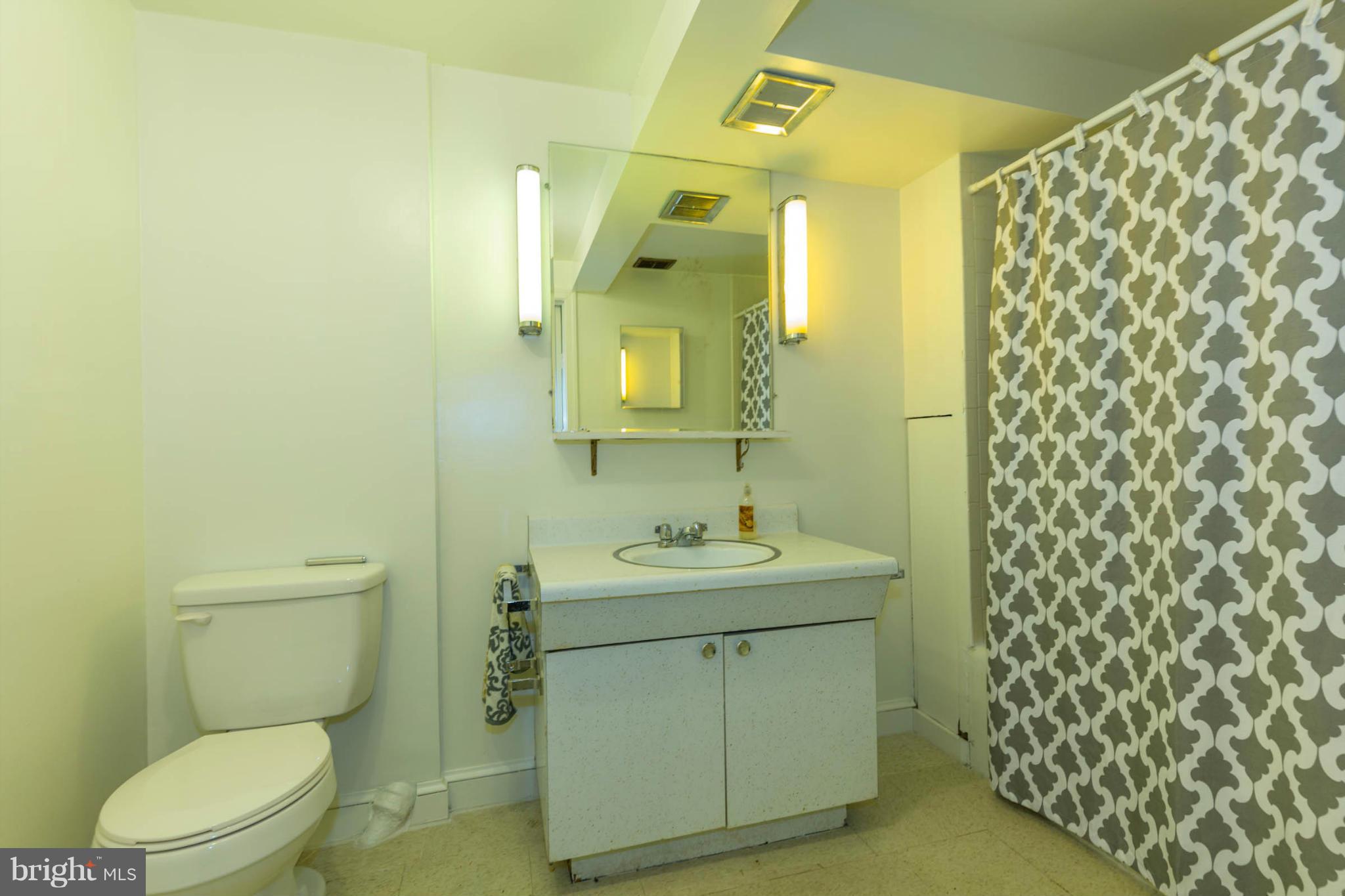 207 Indian Spring Drive Silver Spring, MD 20901 - Photo 28 of 30 a bathroom with a toilet sink vanity and mirror