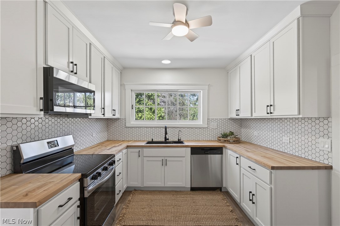 14939 Caves Road Novelty, OH 44072 - Photo 10 of 42 Kitchen featuring butcher block countertops, stainless steel appliances, white cabinets, and ceiling fan