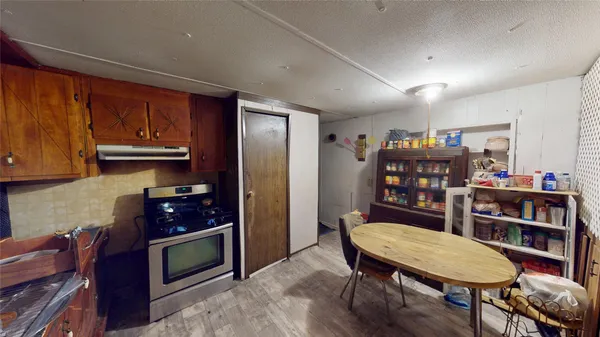 a living room with stainless steel appliances furniture a bookshelf and a refrigerator