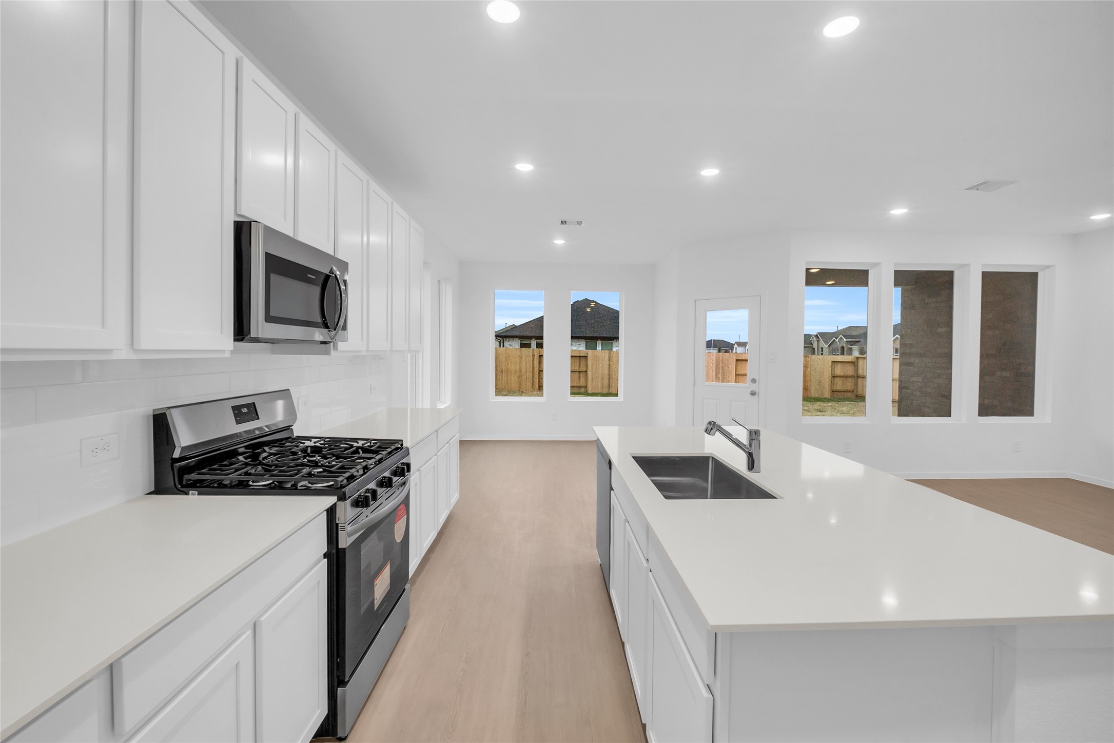 22011 Maddaloni View Drive Hockley, TX 77447 - Photo 13 of 33 a kitchen with stainless steel appliances a stove a sink a microwave a refrigerator and cabinets