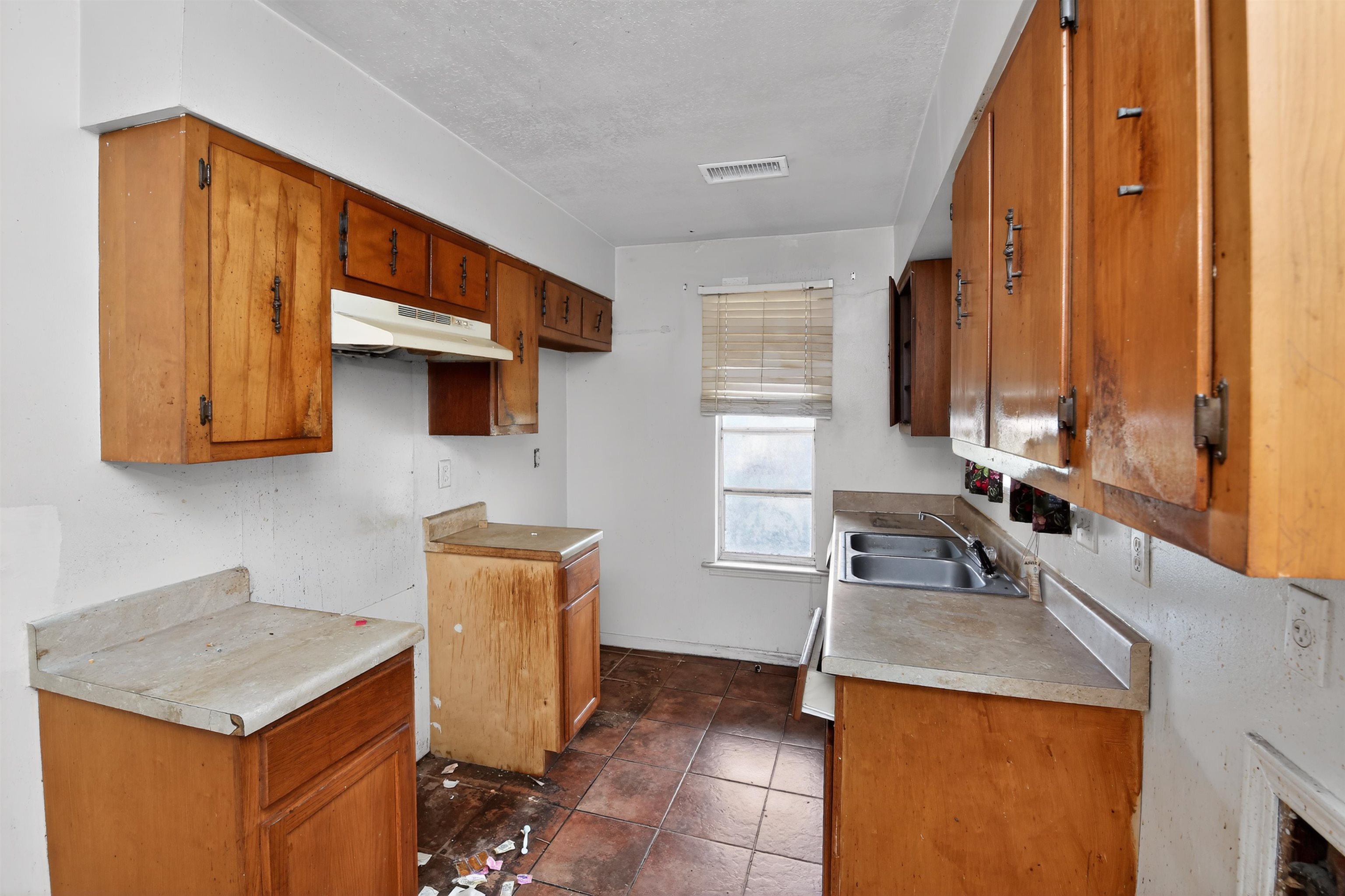 3451 Birdsong Ferry Road Memphis, TN 38118 - Photo 20 of 27 Kitchen space featuring wood cabinetry, laminate countertops, a double-basin stainless steel sink, and tile flooring