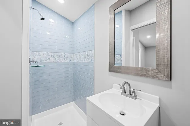 a bathroom with a sink a shower and mirror