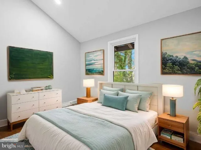 a bedroom with a bed and a flat tv screen on dresser