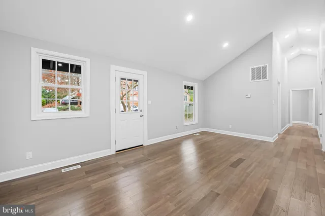 a view of empty room with wooden floor and windows