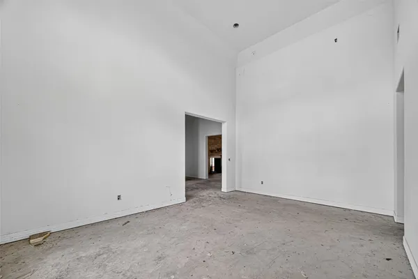 a view of an empty room with a window and a bathroom