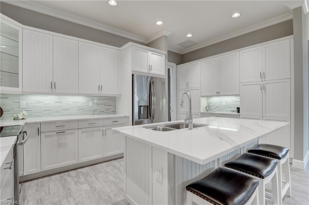 5708 Highbourne Drive Naples, FL 34113 - Photo 9 of 28 a kitchen that has a sink a stove and a refrigerator