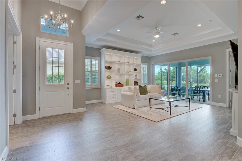 5708 Highbourne Drive Naples, FL 34113 - Photo 10 of 28 a living room with furniture and a chandelier