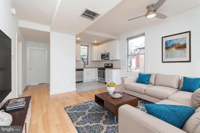 a living room with furniture and kitchen view