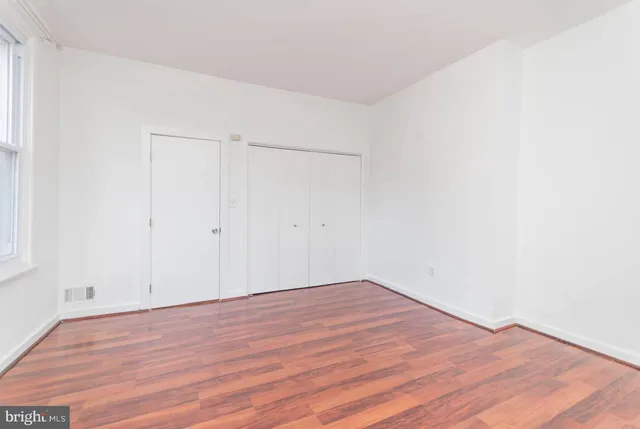 a view of empty room with wooden floor