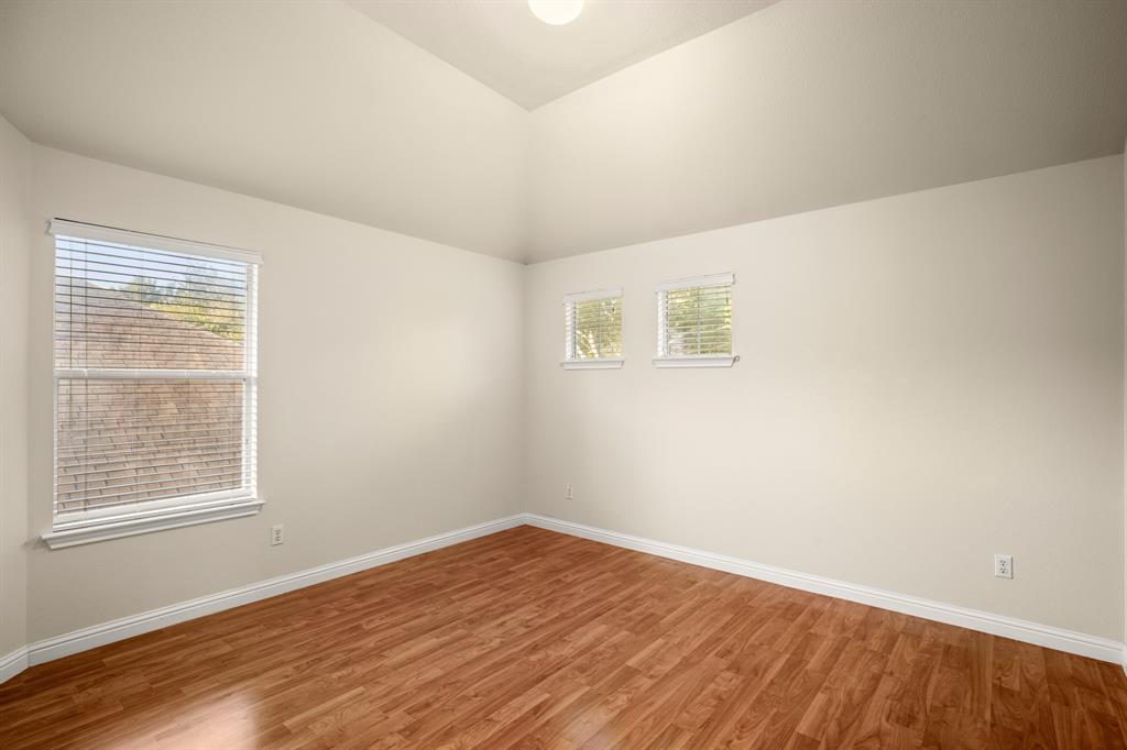 10105 Wind Cave Trail Austin, TX 78747 - Photo 17 of 23 Room featuring wood-finish flooring, white baseboards, and neutral wall paint