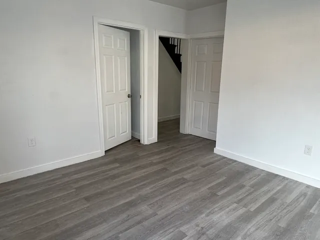 an empty room with wooden floor and closet