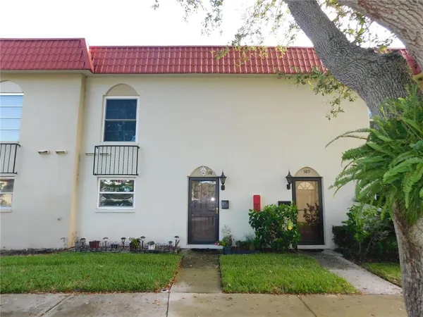 a front view of a house with a yard and potted plants