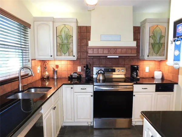 a kitchen with stainless steel appliances granite countertop a sink stove and cabinets