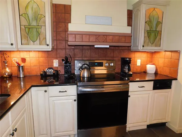 a kitchen with stainless steel appliances granite countertop a stove and a white cabinets