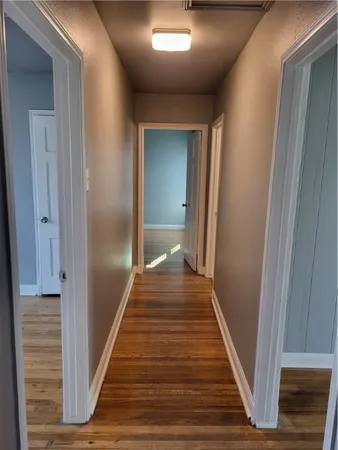 a view of a hallway with wooden floor and staircase