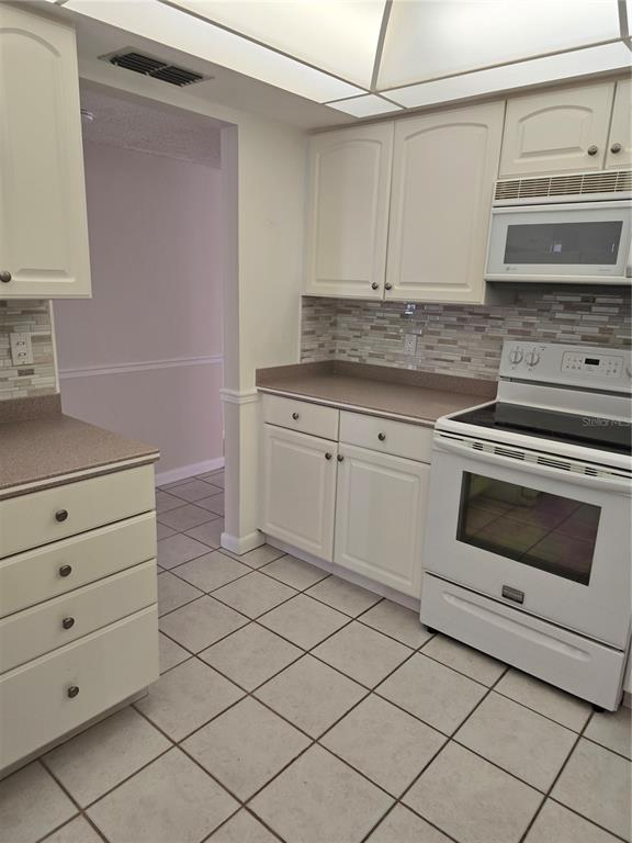 411 South Bayshore Boulevard, Unit 1 Safety Harbor, FL 34695 - Photo 11 of 30 a kitchen with granite countertop white cabinets and white appliances