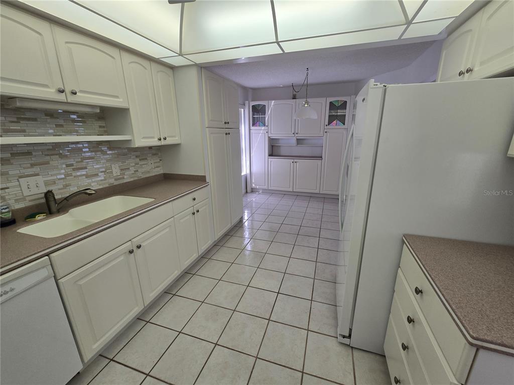 411 South Bayshore Boulevard, Unit 1 Safety Harbor, FL 34695 - Photo 12 of 30 a kitchen with a sink a refrigerator and cabinets