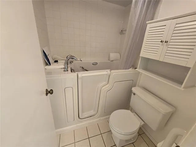 a white toilet sitting next to a shower
