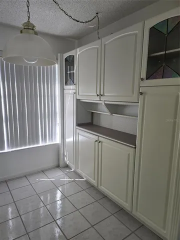 a kitchen with white cabinets and a refrigerator