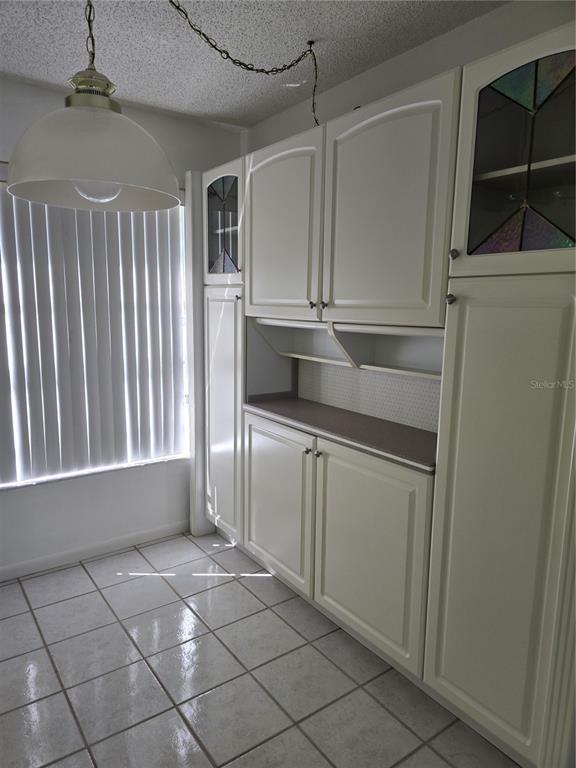 411 South Bayshore Boulevard, Unit 1 Safety Harbor, FL 34695 - Photo 8 of 30 a kitchen with white cabinets and a refrigerator