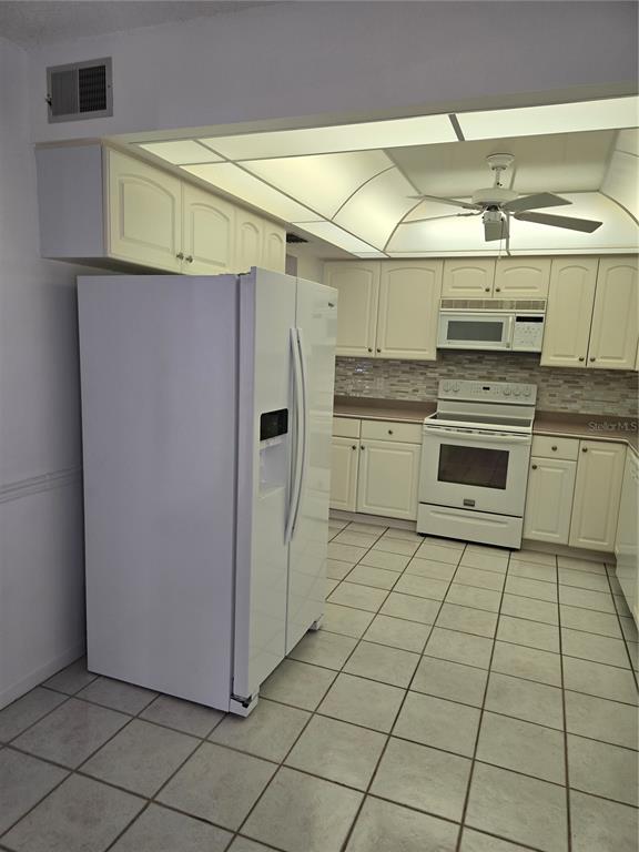 411 South Bayshore Boulevard, Unit 1 Safety Harbor, FL 34695 - Photo 10 of 30 a kitchen with stainless steel appliances granite countertop a refrigerator and a stove top oven
