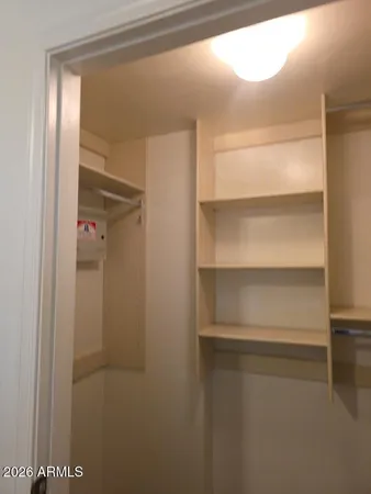 a view of walk in closet with empty racks