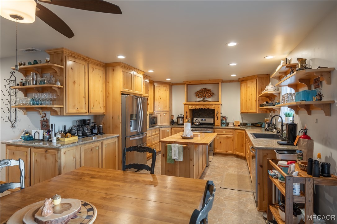 448 Edgemoor Road Big Bear Lake, CA 92315 - Photo 13 of 42 a living room with stainless steel appliances kitchen island granite countertop a table chairs and a refrigerator