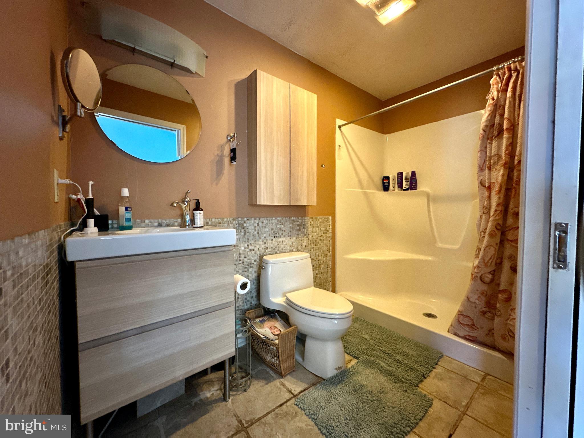 3675 Seaman Road Preston, MD 21655 - Photo 25 of 35 a bathroom with a sink a toilet a mirror and shower