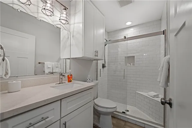 a bathroom with a toilet sink vanity and mirror