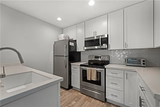 a kitchen with stainless steel appliances granite countertop a stove a microwave and a refrigerator