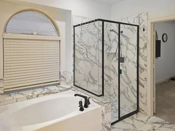 a bathroom with a bathtub and shower